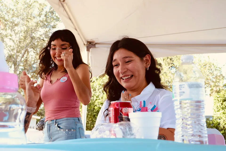 Two women laughing and celebrating at an outdoor baby shower