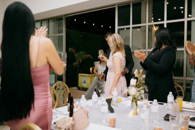 Guests applauding a couple at a dinner celebration